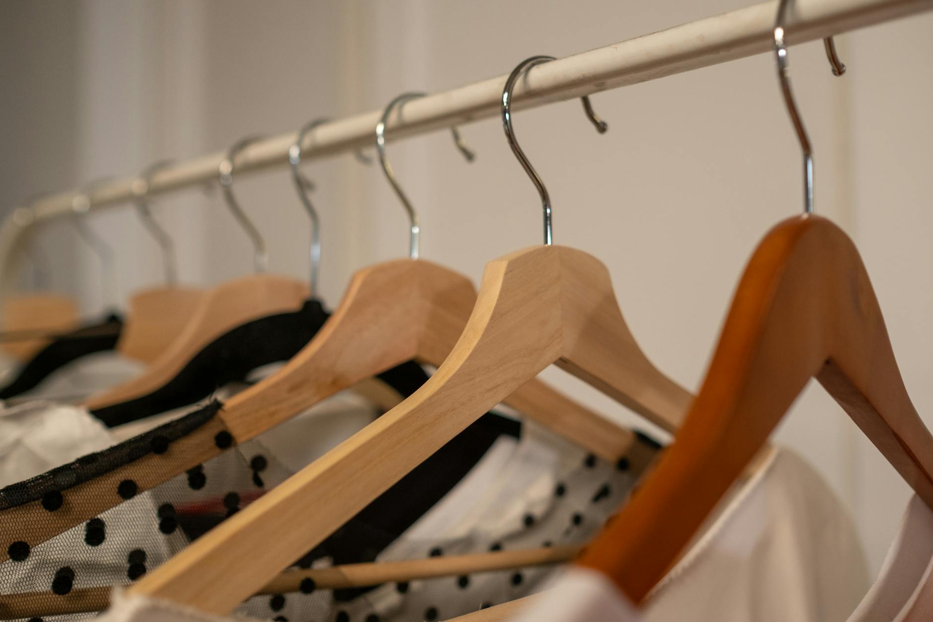 image shows clothes hanging on a metal rack to show a simple, curated wardrobe.